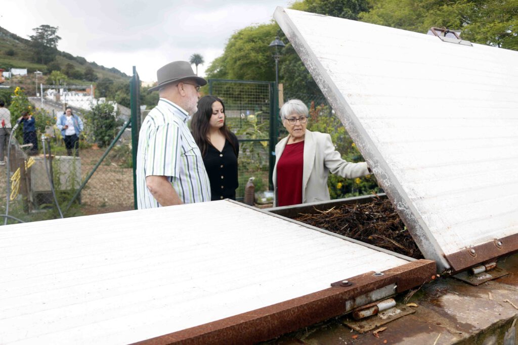 De izquierda a derecha de la imagen, el cabeza de lista de Unidas Sí Podemos al Cabildo de Tenerife, Manuel Marrero, y la candidata al Parlamento por Tenerife, Laura Fuentes, con Carmela Díaz Vilela, observan la zona de vermicompostaje en el huerto urbano de La Atalaya, en Tacoronte.