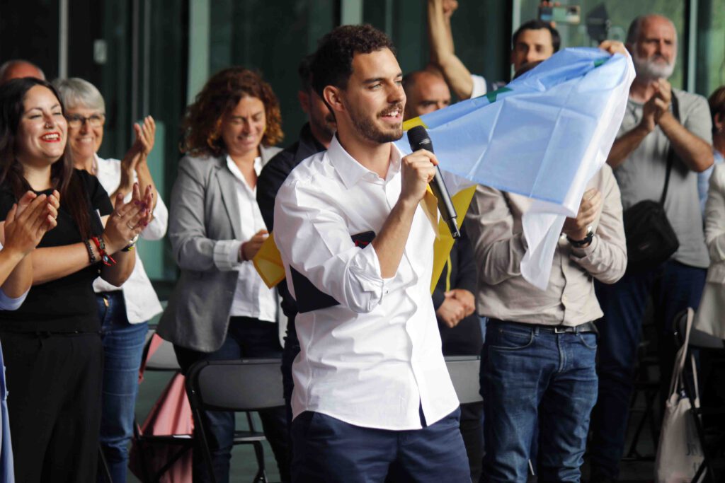 Hugo Cejas enarbola la bandera canaria durante un acto de campaña celebrado en Santa Cruz de Tenerife.